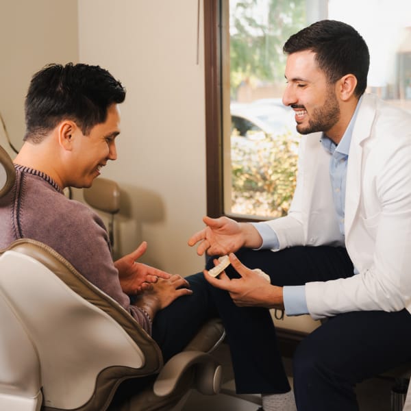 Dr. Marabeh chatting with a patient who's sitting in a dentist's chair