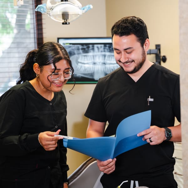 Two members of North County Dental Arts discussing a document