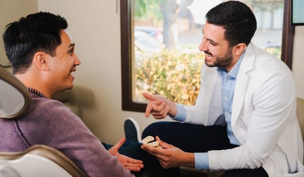 Dr. AJ Marabeh demonstrating a jaw model to a patient
