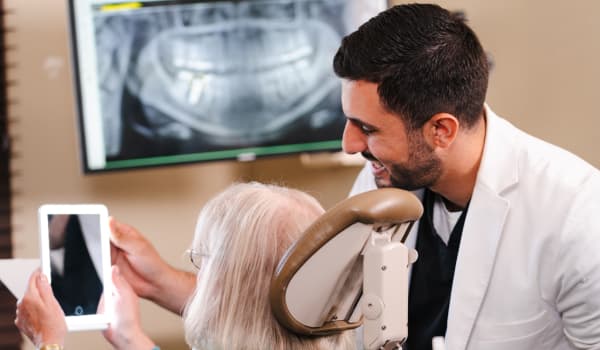 Dr. Marabeh and his patient looking at the patient's new smile in a mirror