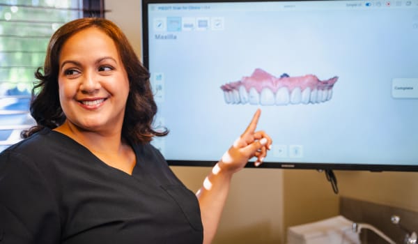 North County Dental Arts assistant pointing at a screen with a 3D model of a jaw