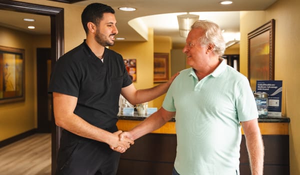 Photo of Dr. AJ Marabeh shaking hands with an older patient in the North County Dental Arts office reception area